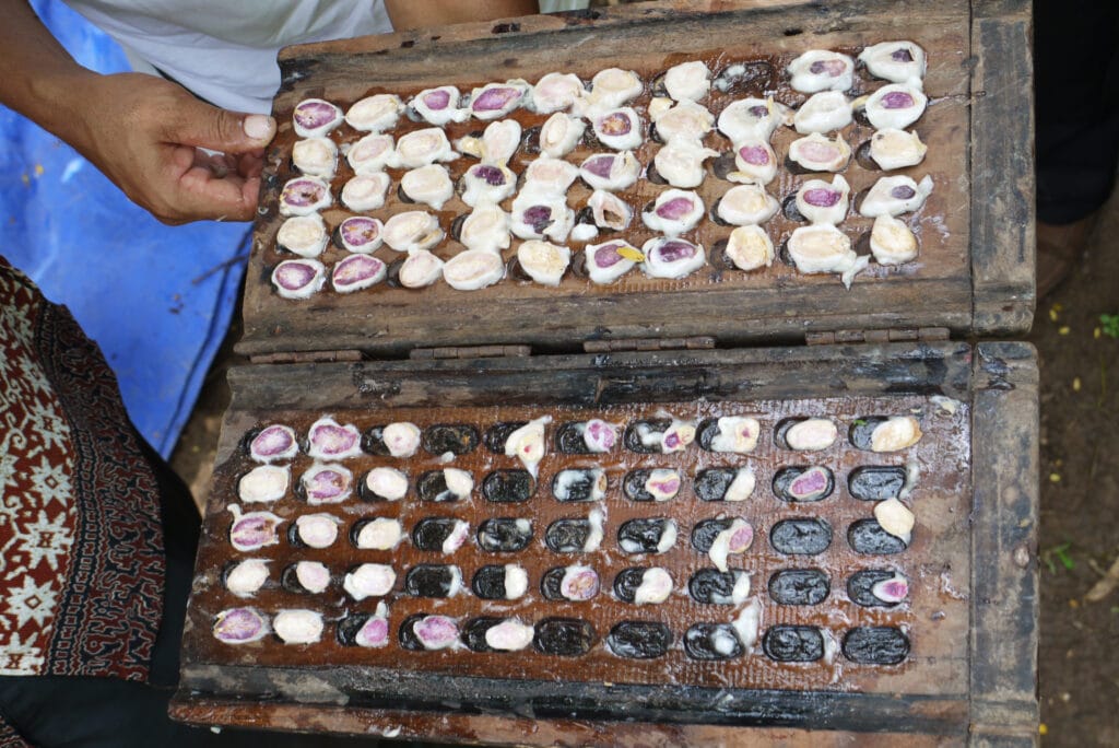 Schnittbrett mit halbierten frischen Kakaobohnen, um die Sortenmischung zu bestimmen. Lila Färbung im Schnitt sind Trinitatiostämme, die weiße Färbung deutet auf Criollo Stämme. Aufgenommen von Crafting Markets auf Java in Indonesien.