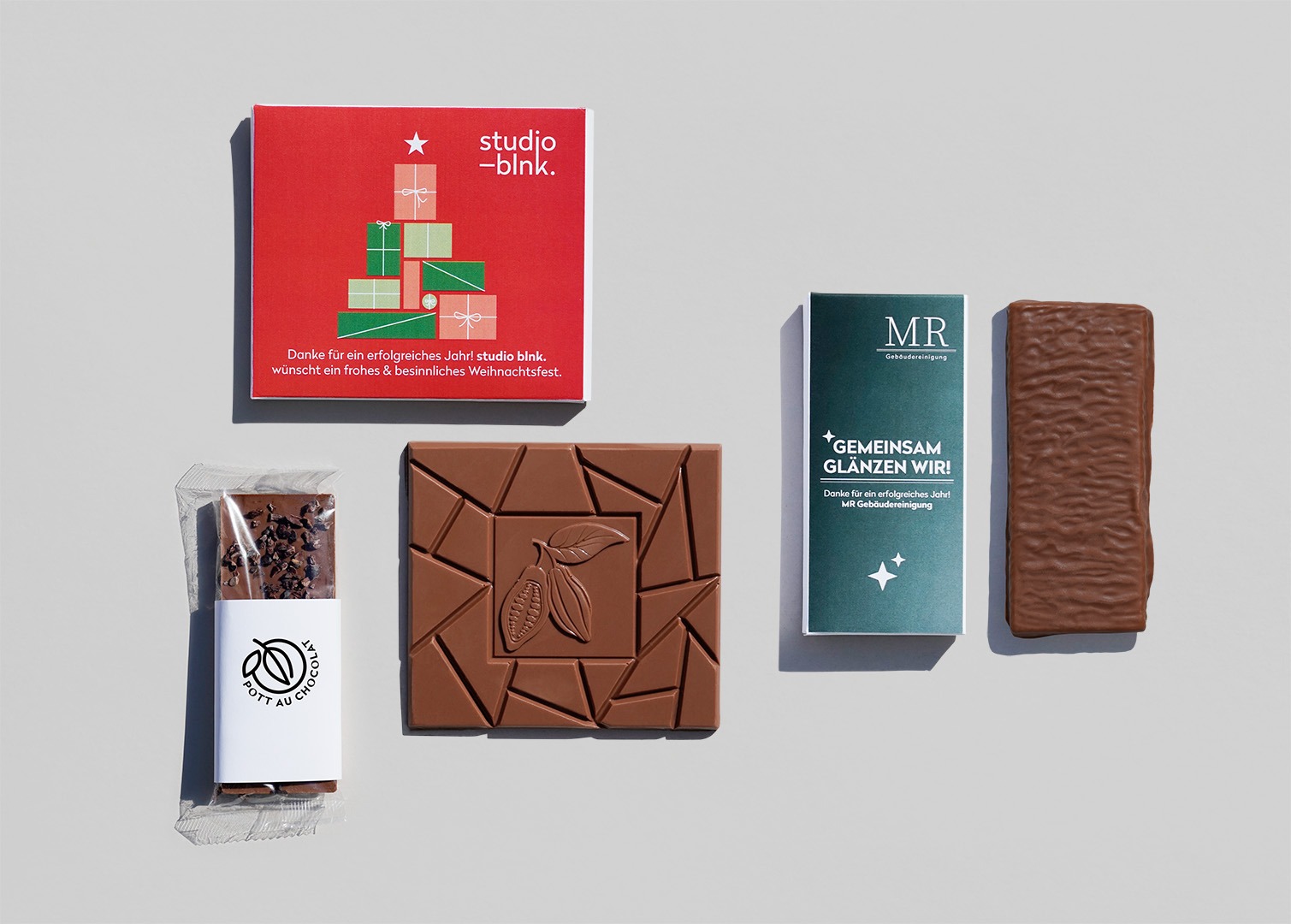 Firmenkunden_Muster_Tafel_Mix Übersicht verschiedener Schokoladentafeln mit individueller Verpackung mit Logos verschiedener Unternehmen.