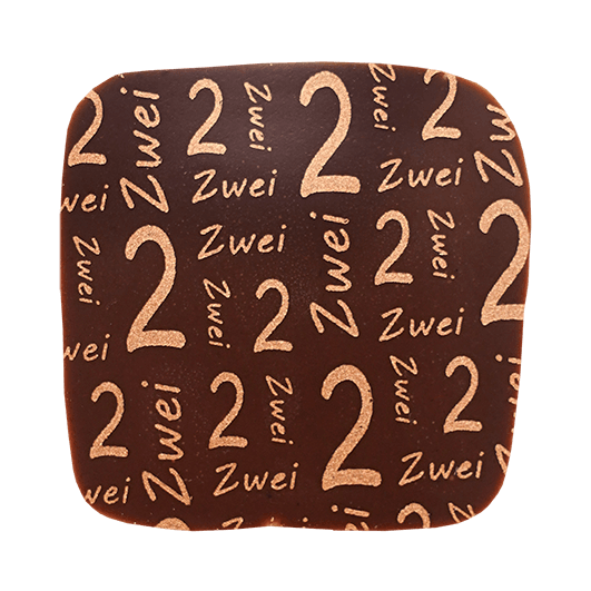 Eckige Praline mit dunkler Schokolade überzogen und mit einem Kupferfarbenen Print mit der Zahl und dem Wort zwei
