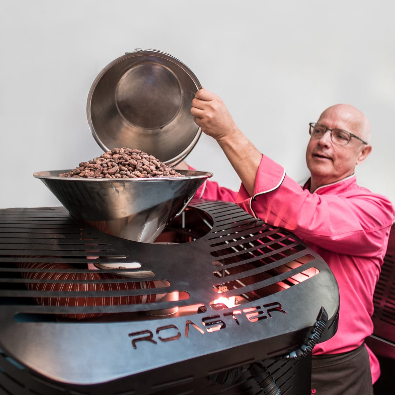 Produktionsleiter Manfred Glatzel von Pott au Chocolat füllt Kakaobohnen in die Röstmaschine.