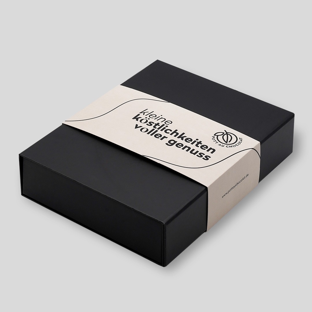 Schwarze Geschenkbox von Pott au Chocolat mit Banderole in beige mit schwarzer Schrift 'Kleine Köstlichkeiten voller Genuss' und Logo von Pott au Chocolat
