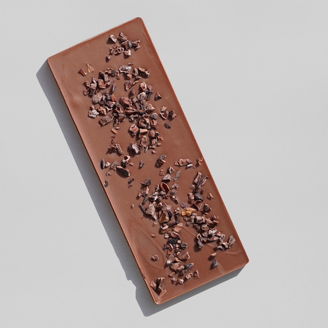 schmale Tafel Schokolade von oben, verziert mit Kakaosplittern