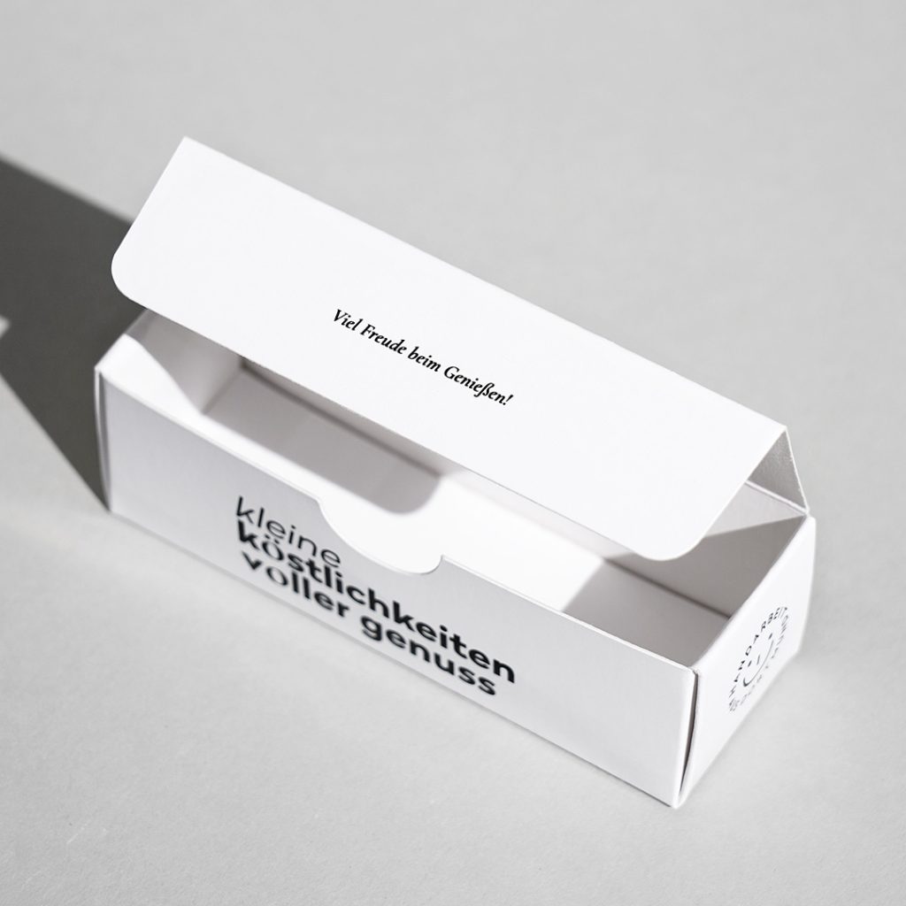 Weiße geöffnete Schachtel für 3 Pralinen mit Logo von Pott au Chocolat.