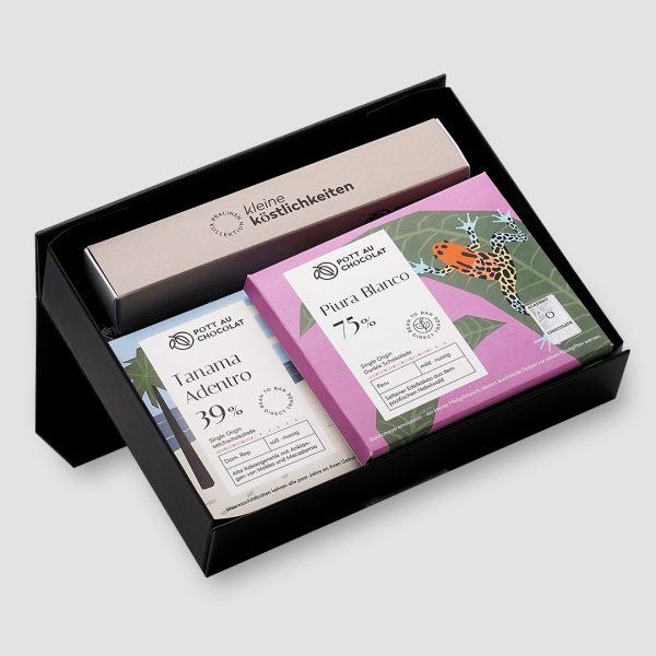 Schwarze Geschenkbox mit einer Pralinen-Stange für 6 Pralinen in beige und schwarz und zwei puren Schokoladen-Tafeln mit buntem Design.