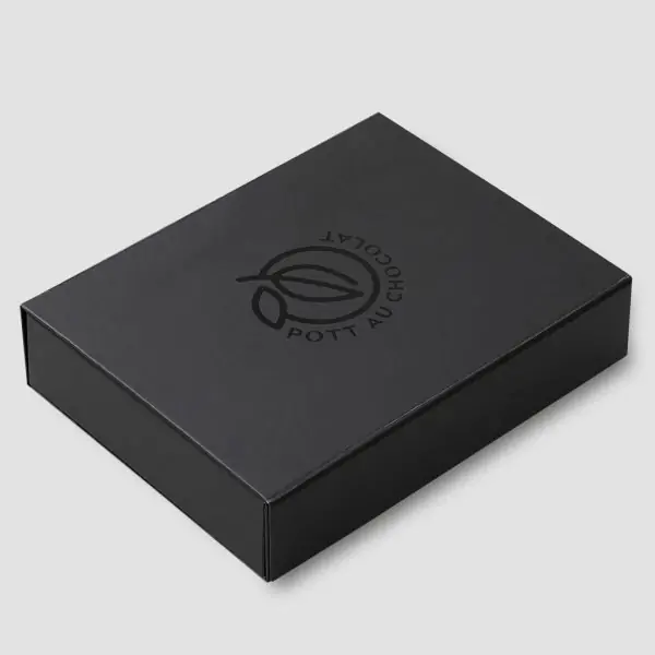 Geschlossene Geschenk Box - komplett schwarz, das Logo von Pott au Chocolat in der Mitte sichtbar. Auch in schwarz mit leichtem Glanz und geprägt.