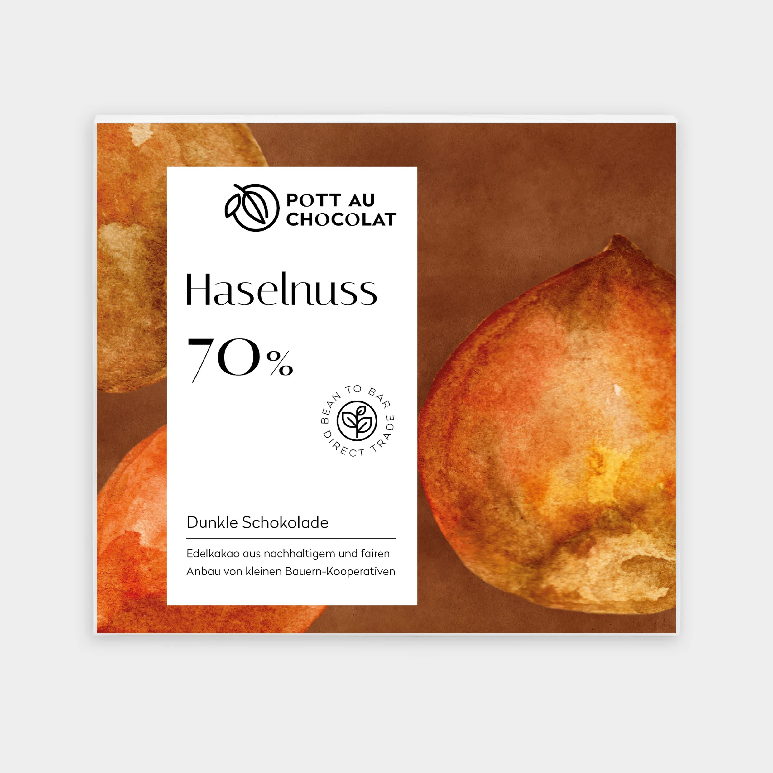 Verpackung unserer dunklen Schokolade belegt mit Haselnüssen. Eine Aquarellzeichnung von braun-rötlich-orangen Haselnusskernen darauf ein weißes Rechteck mit der Bezeichnung und unserem Logo
