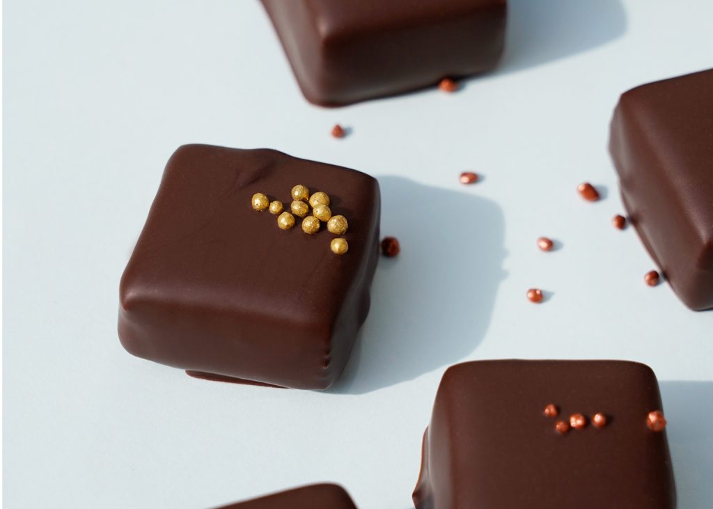 Mit feinen Perlen dekorierte Praline mit Schokoladen Überzug