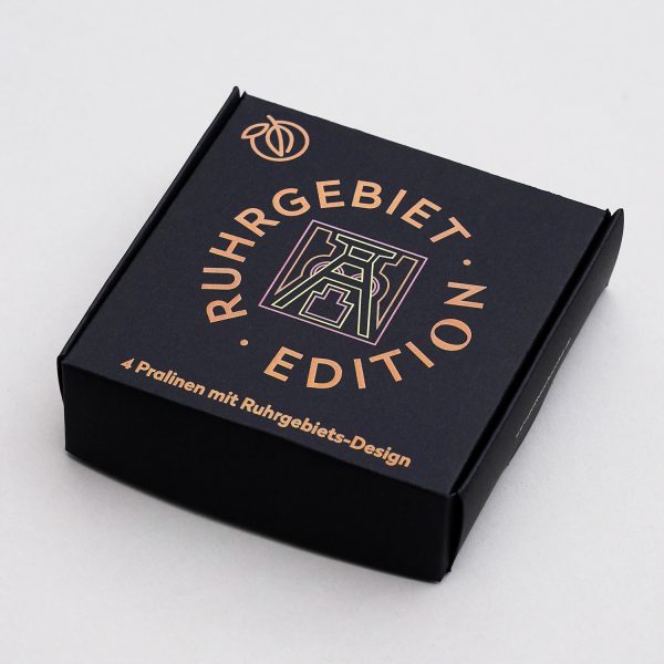 Verpackung der Ruhrgebiet Edition 4er Pralinen. Schwarze Schachtel farbig bedruckt mit Förderturm Motiv.