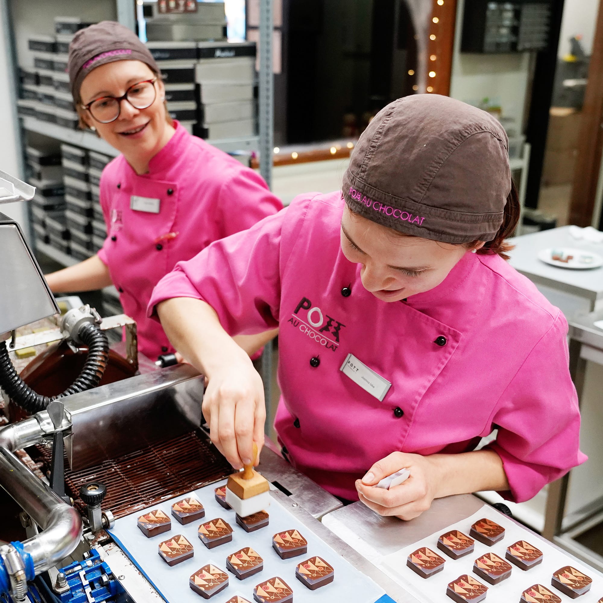 Das Produktionsteam von Pott au Chocolat bedruckt Pralinen in Handarbeit.