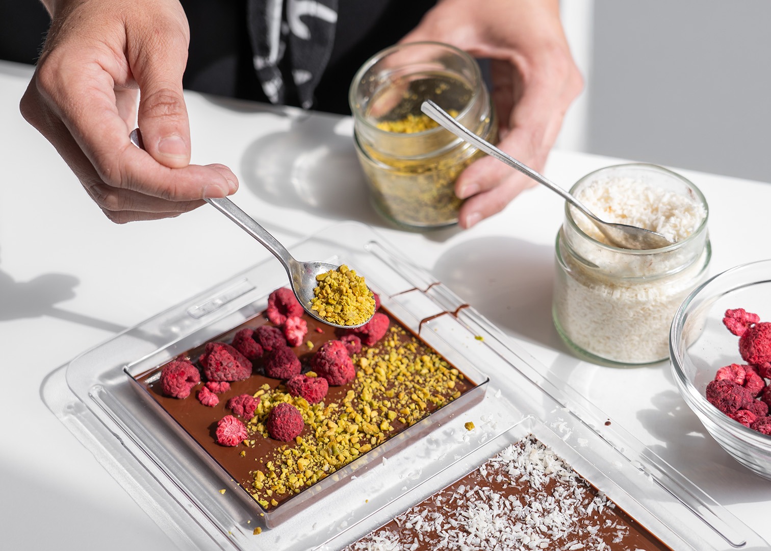 Eine Kurzteilnehmerin belegt ihre Tafel Schokolade mit Pistazien
