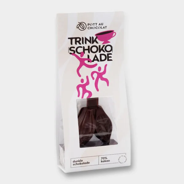 Vorderseite der Verpackung Trinkschokolade am Stiel dunkle Schokolade mit Fenster. Zu sehen ist die Trinkschokolade am Stiel als Doppel-Kakaofrucht. Auf der Verpackung sind eine Tasse und tanzende Figuren zu sehen. Farben: Weiße Verpackung mit Pink und Braun