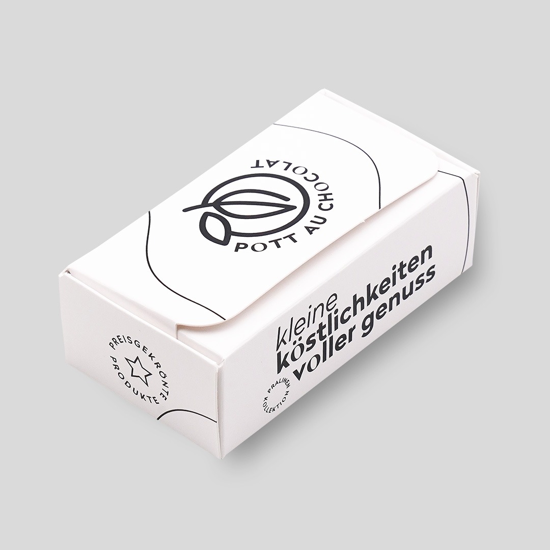 Geschlossene Verpackung für zwei Macarons aus weißem Karton, bedruckt mit schwarzer Schrift 'Kleine Köstlichkeiten voller Genuss' und dem Logo von Pott au Chocolat.