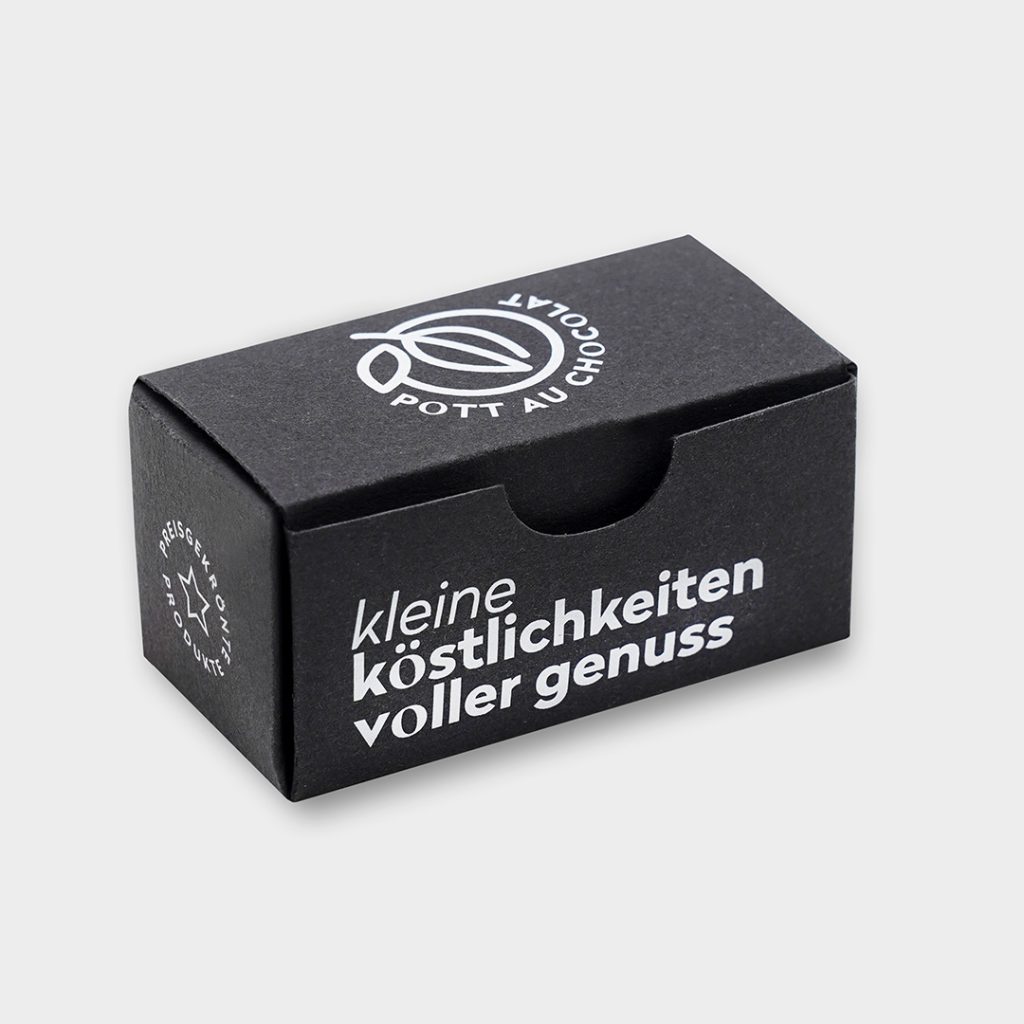 Verpackung aus schwarzer Pappe für 2 Pralinen weiß bedruckt mit Logo und 'kleine Köstlichkeiten für dich'