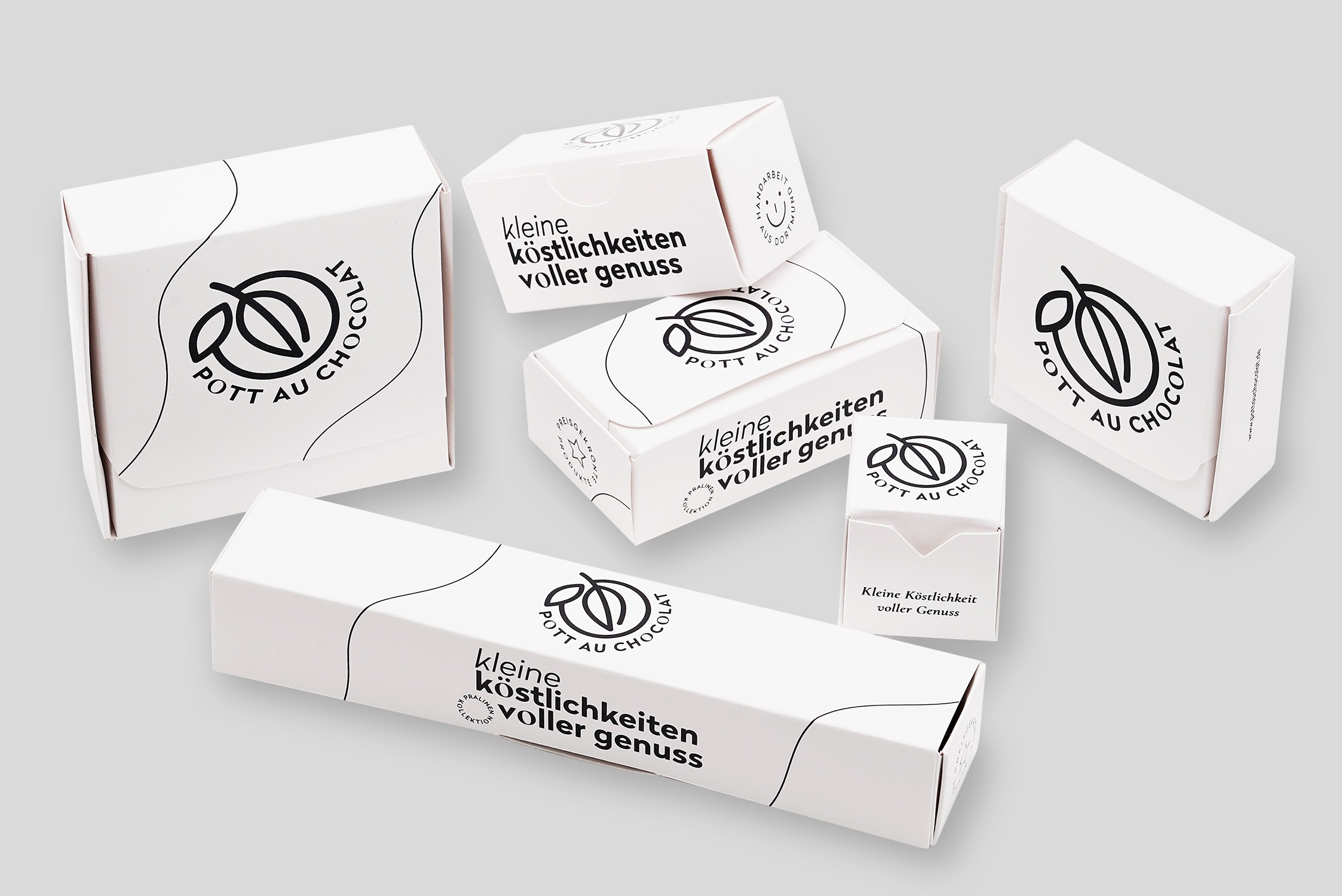 Verschiedene kleinere Verpackungen aus Papier von Pott au Chocolat mit eigenem Design in schwarz weiß.