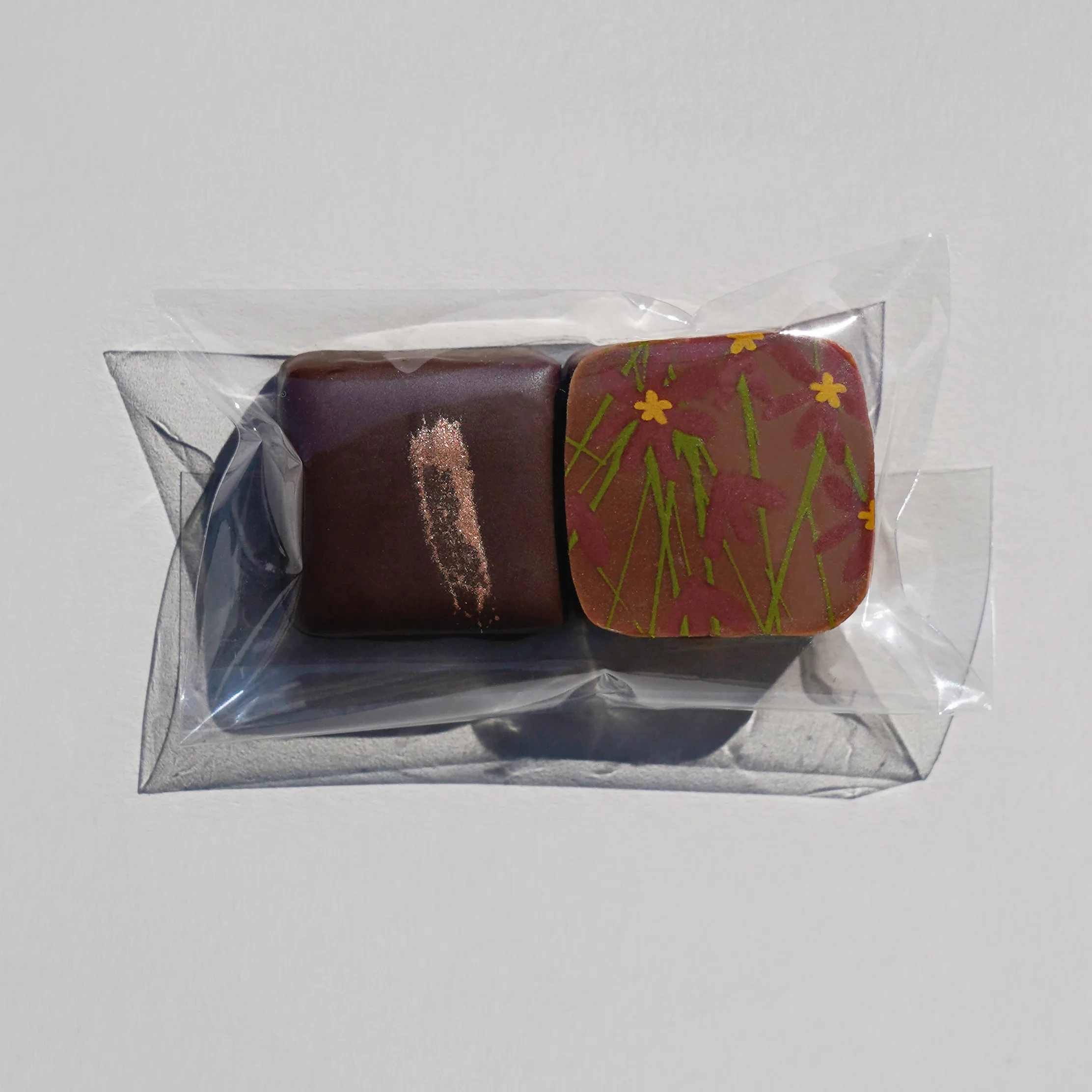 zwei Pralinen nebeneinander in einer Cellophan Verpackung