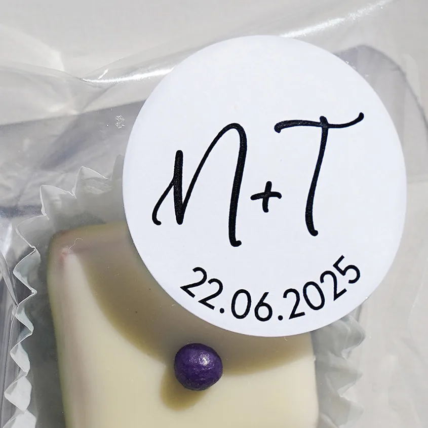 Close-Up von eine Praline im Tütchen mit weissem Überzug versehen mit einem individualisierten runden Etikett