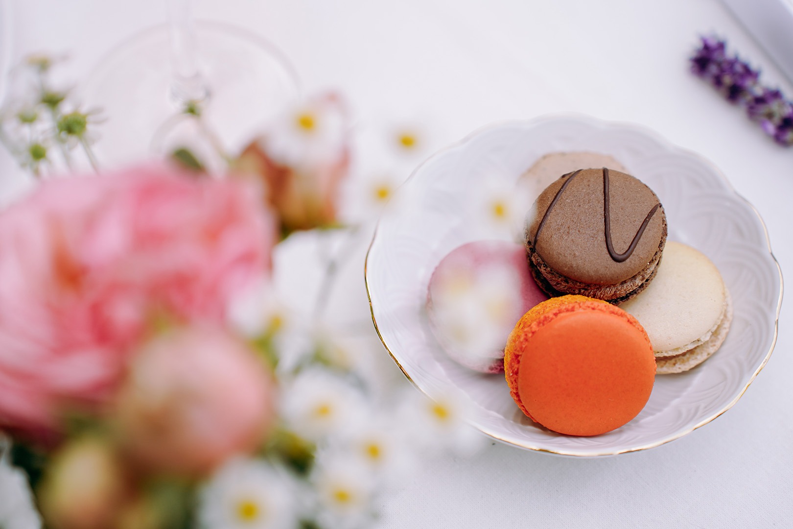 Macarons und Blumen auf einem Tisch.