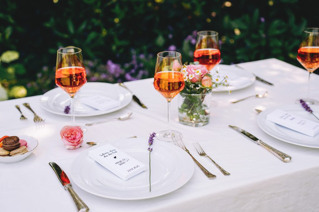 Gedeckter Tisch für eine Hochzeit im Grünen mit Schokolade auf den Tellern