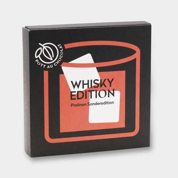 Aufgestellte Pralinenbox 'Whisky Edition'. Design in den Farben Schwarz, Orange und Weiß mit einer abstrakten Darstellung eines Glases mit Whisky und Eiswürfeln