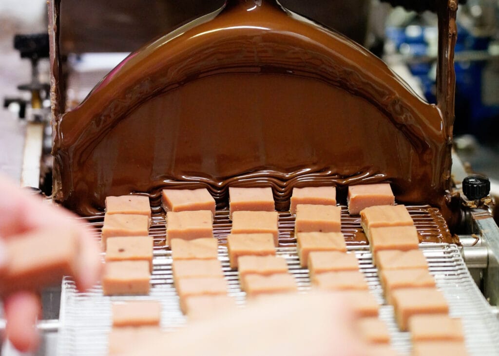 In der Produktion: Ganache wird mit Schokolade überzogen