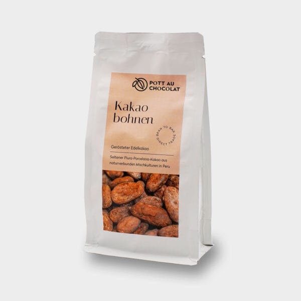 Umverpackung unserer gerösteten Kakaobohnen aus Kolumbien. Weisser Standbodenbeutel mit hellbraunem Etikett darauf ein Foto der Bohnen