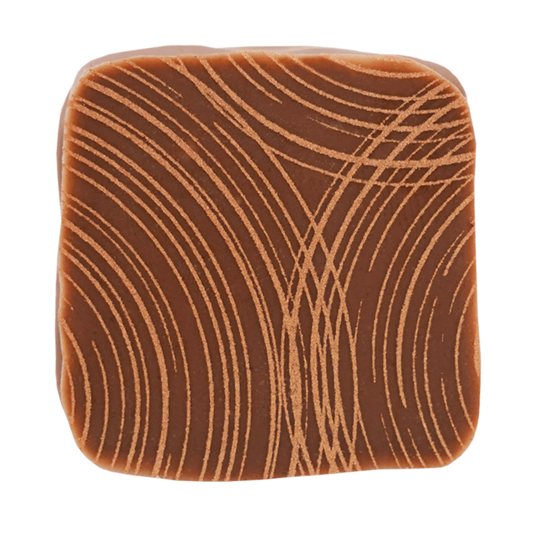 Praline in Milchschokolade mit Muster aus feinen Linien aus gefärbter Kakaobutter in Bronze.